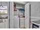 Laundry area featuring a stacked washer and dryer, shelves, and white cabinets, conveniently located in the kitchen at 4306 Lake Underhill Rd # C, Orlando, FL 32803