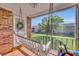 Charming porch with a hanging swing, view of landscaped yard, and brick accents at 4306 Lake Underhill Rd # C, Orlando, FL 32803