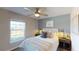 Comfortable bedroom with a ceiling fan, a plush bed, and a large window that lets in natural light at 4718 Golden Knight Blvd, Kissimmee, FL 34746