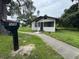 Exterior view of home featuring a black mailbox and walkway leading to a screened-in porch at 506 South St, Daytona Beach, FL 32114
