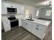 Bright kitchen with white cabinets, stainless steel appliances, and modern fixtures at 506 South St, Daytona Beach, FL 32114