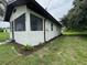 Side view of the home features freshly painted exterior, manicured lawn, and new landscaping at 506 South St, Daytona Beach, FL 32114