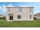 Spacious backyard with lush green grass and a modern home exterior featuring large windows and a sliding glass door at 510 Coronado Cove Rd, New Smyrna Beach, FL 32168
