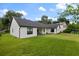 Expansive backyard featuring lush green lawn and a white home exterior with black trim and a covered patio at 5237 Haverill Dr, Orlando, FL 32809