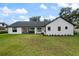 Wide shot of a spacious backyard with a well-manicured lawn and a modern home with black-framed windows at 5237 Haverill Dr, Orlando, FL 32809