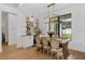 Elegant dining room featuring a modern light fixture, floating shelves, wine storage, and hardwood floors at 5237 Haverill Dr, Orlando, FL 32809