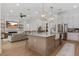 Open concept kitchen featuring white cabinets, pendant lighting, large island with seating and stainless steel appliances at 5237 Haverill Dr, Orlando, FL 32809