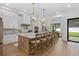 Open kitchen with a center island featuring pendant lighting, white cabinetry, and stainless steel appliances at 5237 Haverill Dr, Orlando, FL 32809