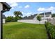 Large, grassy yard enclosed by a white vinyl fence, showcasing a well-maintained landscape and blue skies at 5237 Haverill Dr, Orlando, FL 32809