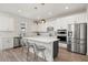 Modern kitchen featuring a large island, stainless steel appliances, and sleek white cabinets with gold hardware at 5700 Iron Brand Rd, St Cloud, FL 34771