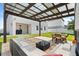 Backyard featuring a modern pergola with seating, outdoor dining area, and manicured lawn at 5700 Iron Brand Rd, St Cloud, FL 34771