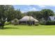 Lush backyard featuring a rock waterfall pool and covered patio, bordering a golf course at 5950 Blakeford Dr, Windermere, FL 34786