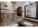 Bathroom featuring a shower with neutral walls, a sink with granite countertop, and dark wood cabinets at 5950 Blakeford Dr, Windermere, FL 34786
