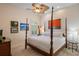 Cozy bedroom with a four-poster bed, ceiling fan and shuttered windows that provide natural light at 5950 Blakeford Dr, Windermere, FL 34786