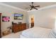 Bedroom features neutral walls, a ceiling fan, a television, and a decorative dresser at 5950 Blakeford Dr, Windermere, FL 34786