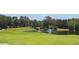Scenic view of a lush golf course with a serene pond and fountain at 5950 Blakeford Dr, Windermere, FL 34786