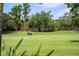 A golfer is seen driving the golf cart across the lush golf course on a sunny day at 5950 Blakeford Dr, Windermere, FL 34786
