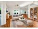 Bright living room with hardwood floors, plush seating, and French doors leading to the backyard at 704 Pickfair Ter, Lake Mary, FL 32746