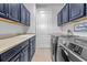 Functional laundry room equipped with modern washer/dryer units and ample cabinet storage at 808 Sherbourne Cir, Lake Mary, FL 32746
