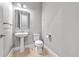 Neutral powder room features pedestal sink, decorative mirror, and tile flooring at 808 Sherbourne Cir, Lake Mary, FL 32746