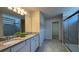 Bathroom offers a double vanity with granite countertops and a glass-enclosed shower at 8926 Zurich Ln, Kissimmee, FL 34747