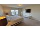Bright bedroom with a queen size bed, a TV, and bright white furnishings at 8926 Zurich Ln, Kissimmee, FL 34747