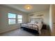 Bright bedroom with a metal bed frame and a view of the neighborhood through the windows at 8926 Zurich Ln, Kissimmee, FL 34747