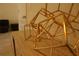 Geometric gold artwork on wooden table adds a modern, decorative touch to any living space at 8926 Zurich Ln, Kissimmee, FL 34747