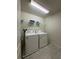 Functional laundry room with a washer, dryer, and convenient overhead shelving at 8926 Zurich Ln, Kissimmee, FL 34747