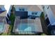 Aerial view of a screened-in swimming pool, surrounded by the house and lush greenery at 8926 Zurich Ln, Kissimmee, FL 34747