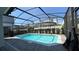 Beautiful screened-in pool with clear blue water, surrounded by brick pavers and manicured hedges at 8926 Zurich Ln, Kissimmee, FL 34747