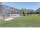 Well-maintained backyard showcasing an enclosed patio area and lush green lawn at 927 Orange Cosmos Blvd, Davenport, FL 33837