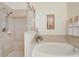 Bright bathroom features a soaking tub and separate shower with neutral toned tile and modern fixtures at 927 Orange Cosmos Blvd, Davenport, FL 33837