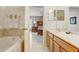 Bright bathroom with soaking tub, vanity, and neutral tile, and open access to bedroom at 927 Orange Cosmos Blvd, Davenport, FL 33837