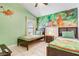 Fun ' bedroom featuring twin beds, tiled floors, and a colorful mural on the wall at 927 Orange Cosmos Blvd, Davenport, FL 33837