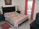 Comfortable bedroom features a patterned comforter, two side tables with lamps, and neutral tiled floors at 927 Orange Cosmos Blvd, Davenport, FL 33837