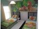 Bright bedroom with two twin beds, colorful mural, and a ceiling fan at 927 Orange Cosmos Blvd, Davenport, FL 33837