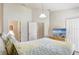 Bright and airy bedroom with a king-size bed, modern decor, and multiple doors at 927 Orange Cosmos Blvd, Davenport, FL 33837