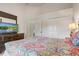 The bedroom features a dresser with a TV, a closet, and a patterned comforter on the bed at 927 Orange Cosmos Blvd, Davenport, FL 33837