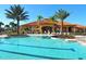 Beautiful community pool with lounge chairs and a clubhouse in a tropical setting at 927 Orange Cosmos Blvd, Davenport, FL 33837