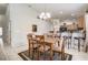Bright dining room with wood table, seating for six, chandelier, and kitchen bar access at 927 Orange Cosmos Blvd, Davenport, FL 33837