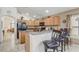 Well-lit kitchen featuring wood cabinets, tile floors, and an eat-in bar area with seating at 927 Orange Cosmos Blvd, Davenport, FL 33837