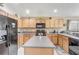 Functional kitchen with wood cabinets, stainless steel appliances, and a center island at 927 Orange Cosmos Blvd, Davenport, FL 33837