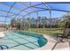 Screened-in pool with clear blue water, surrounded by lush greenery and chairs at 927 Orange Cosmos Blvd, Davenport, FL 33837
