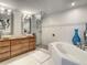 Bright bathroom with a double vanity, soaking tub, glass enclosed shower and neutral tile flooring at 100 S Eola Dr # 611, Orlando, FL 32801