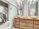 Bright bathroom with a double vanity, soaking tub, glass enclosed shower and neutral tile flooring at 100 S Eola Dr # 611, Orlando, FL 32801