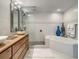 Modern bathroom featuring double sinks, a glass shower, and a luxurious soaking tub at 100 S Eola Dr # 611, Orlando, FL 32801