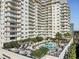 Expansive pool deck featuring a swimming pool, lounge chairs, cabanas and well manicured trees and shrubbery at 100 S Eola Dr # 611, Orlando, FL 32801