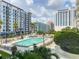 Exterior shot of a pool and surrounding landscaping, set against a backdrop of modern condo buildings at 100 S Eola Dr # 611, Orlando, FL 32801
