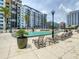 Community pool surrounded by lounge chairs, palm trees, and views of the condo buildings at 100 S Eola Dr # 611, Orlando, FL 32801